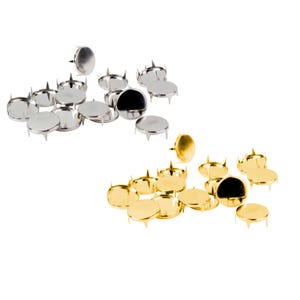 May include: A selection of silver and gold upholstery tacks. Each tack has a flat, circular head and four small prongs. The tacks are arranged in two groups against a white backdrop. The silver tacks are at the top, and the gold tacks are at the bottom.