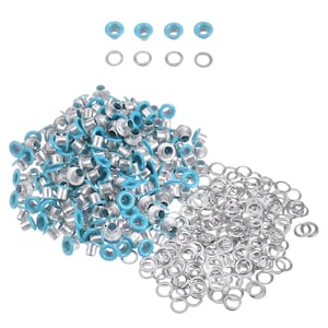 Könnte beinhalten: Eine Sammlung von silbernen Metallösen mit hellblauem Rand. Einige Ösen sind lose, während andere gruppiert sind. Einige lose silberne Ösen sind ebenfalls sichtbar.