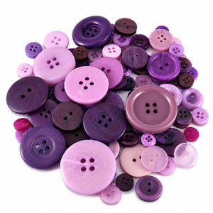 May include: A collection of assorted sewing buttons in various shades of purple, lavender, lilac, and pink. The buttons vary in size, texture, and finish, featuring two or four holes for attachment, with some displaying embossed patterns or text.
