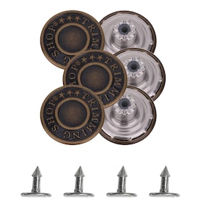 May include: A collection of bronze metal jean buttons, each with the text "SHOP TRIMMING" around the edge. The set includes button tops, button backs, and four silver rivets, displayed on a white background.