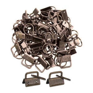 Op de afbeelding: Een stapel antiek bronzen metalen hardware, waaronder rechthoekige sluitingen, D-ringen en sleutelringen. Twee sluitingen met pinnen worden onderaan weergegeven. De hardware is waarschijnlijk voor knutselen of het maken van sieraden.