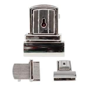 May include: Three silver-toned metal purse clasps are displayed. The main clasp has a rectangular design with a keyhole. Two smaller clasps are also shown, one with a ribbed texture and the other with a simple, rectangular shape.