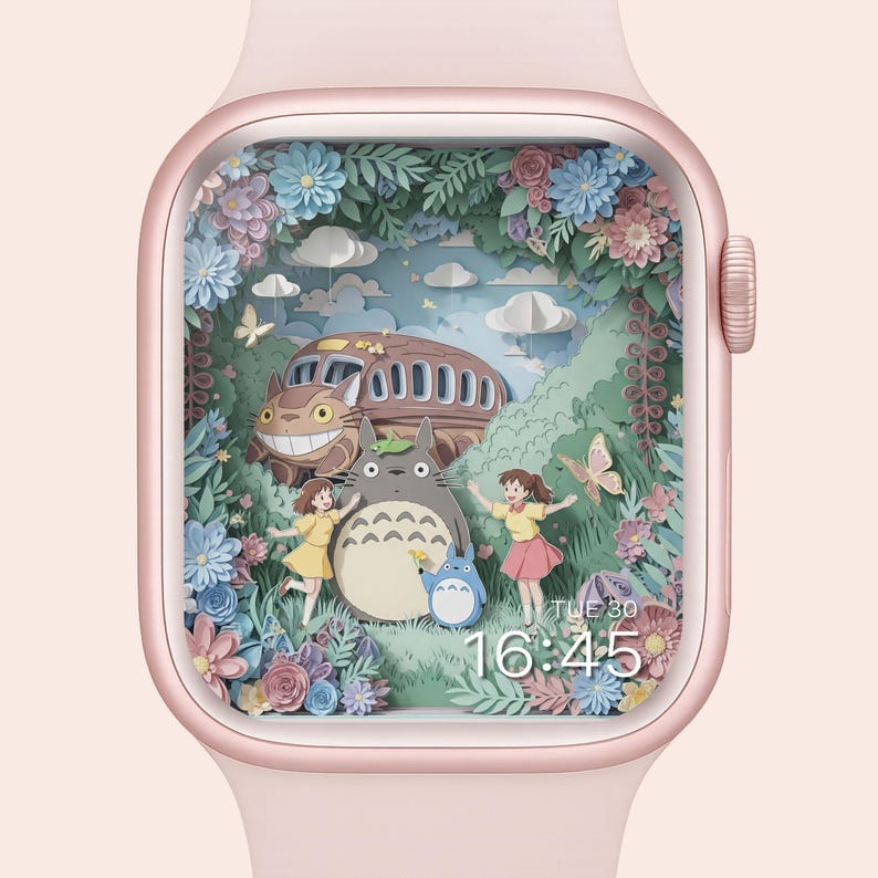 May include: A pink smartwatch displays a colorful illustration of a forest scene with animated characters. The scene includes a bus, a large gray creature, two girls, and a smaller blue creature, surrounded by flowers and butterflies. The time is 16:45.