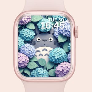 Può includere: Uno smartwatch color oro rosa mostra un'illustrazione digitale di un personaggio dei cartoni animati grigio circondato da ortensie blu, viola e rosa. Il quadrante mostra l'ora, 16:45, e il giorno, mar. 30.