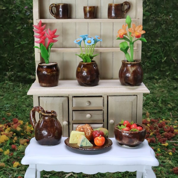 Miniature hand-thrown, hand-glazed, kiln-fired vases, flower pots, cups, pitcher, fruit bowl, and platter. Earth color scheme.