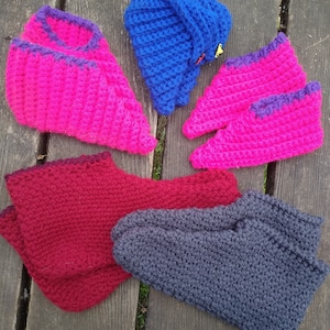 May include: Five pairs of crocheted slippers in different colors. The slippers are made of soft yarn and have a comfortable fit. The colors include pink, blue, red, and gray.