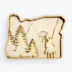 May include: A wooden cutout of the state of Oregon with a cowboy riding a horse and lassoing in front of a mountain and pine trees.