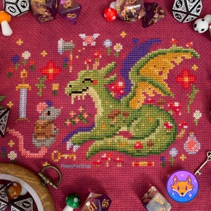 May include: Cross stitch pattern featuring a green dragon with purple wings, a brown mouse, and a variety of flowers and mushrooms. The pattern is on a red background and includes the text "FlossyFoxShop".