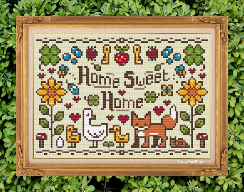 Pode incluir: Padr&atilde;o de ponto cruz com um design floral verde, marrom e amarelo com um ganso branco, uma raposa laranja e o texto "Home Sweet Home".
