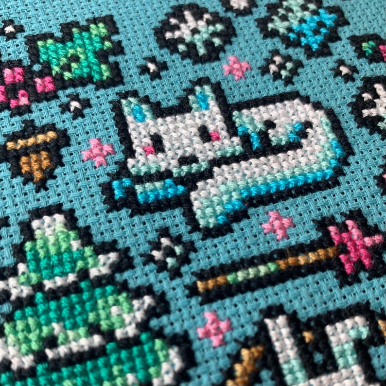 Pu&ograve; includere: Motivo a punto croce su tessuto azzurro chiaro raffigurante un unicorno bianco con accenti blu, circondato da stelle e altri elementi decorativi. Il design include una bacchetta magica e altri dettagli colorati, ideale per un progetto artigianale.