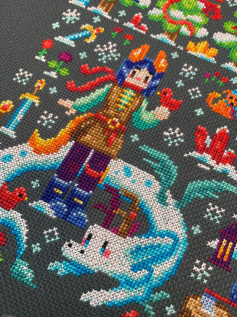 May include: A cross-stitch pattern featuring a colorful character with a red scarf and a white unicorn on a gray background. The character is wearing a brown vest and blue pants. The unicorn is surrounded by blue and white waves.