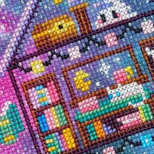 K&ouml;nnte beinhalten: Ein detailliertes Kreuzstichst&uuml;ck mit einer skurrilen Szene mit einem Haus, B&uuml;cherregalen und einem niedlichen Charakter. Das Kunstwerk verwendet eine lebendige Palette aus Blau-, Lila-, Rosa- und Gelbt&ouml;nen und schafft ein farbenfrohes und strukturiertes Design.