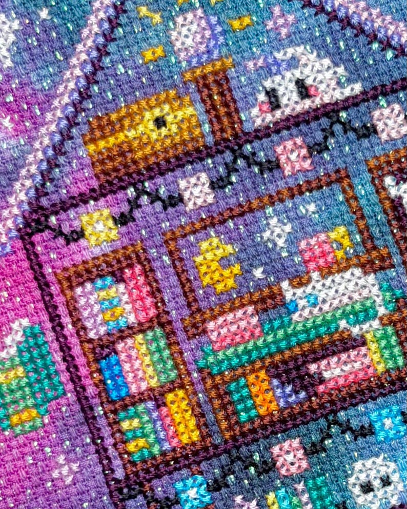 K&ouml;nnte beinhalten: Ein detailliertes Kreuzstichst&uuml;ck mit einer skurrilen Szene mit einem Haus, B&uuml;cherregalen und einem niedlichen Charakter. Das Kunstwerk verwendet eine lebendige Palette aus Blau-, Lila-, Rosa- und Gelbt&ouml;nen und schafft ein farbenfrohes und strukturiertes Design.