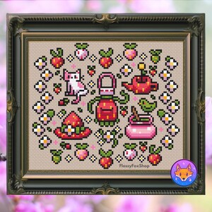 May include: Cross-stitch artwork in a dark green frame, depicting a garden scene. The design includes strawberries, flowers, a watering can, a cat, and a hat. The color scheme is predominantly pink, red, green, and white. The artwork is signed with the text "FlossyFoxShop".