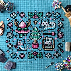 Pu&ograve; includere: Un disegno a punto croce su sfondo turchese con elementi a tema invernale. Il disegno include un gatto, un albero di Natale, un coniglio in un cesto e fiocchi di neve. Il testo "FlossyFoxShop" &egrave; visibile in basso.
