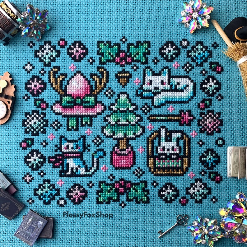 Pu&ograve; includere: Un disegno a punto croce su sfondo turchese con elementi a tema invernale. Il disegno include un gatto, un albero di Natale, un coniglio in un cesto e fiocchi di neve. Il testo "FlossyFoxShop" &egrave; visibile in basso.