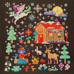 May include: A cross-stitch pattern depicting a winter scene with a small house, a flying unicorn, a deer, a rabbit, a witch, and a campfire. The scene is set against a dark blue background with white snowflakes.