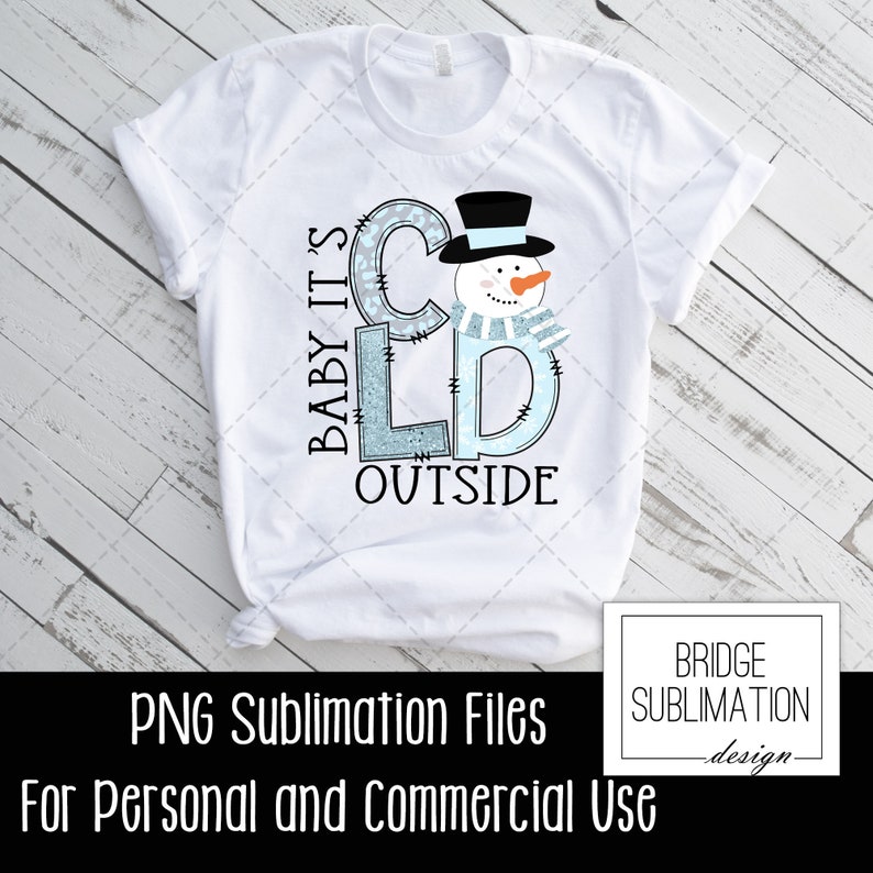 May include: A white t-shirt with a blue and white snowman design. The text "Baby It's Cold Outside" is written in a blue and white font. The design is perfect for sublimation.