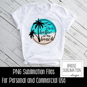 Op de afbeelding: Een wit T-shirt met een sublimatieontwerp van een palmboom en oceaan golven. Het ontwerp bevat de tekst "Life is better at the beach".