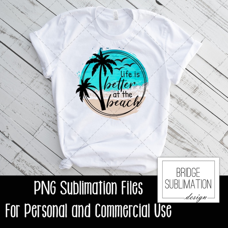 Op de afbeelding: Een wit T-shirt met een sublimatieontwerp van een palmboom en oceaan golven. Het ontwerp bevat de tekst "Life is better at the beach".