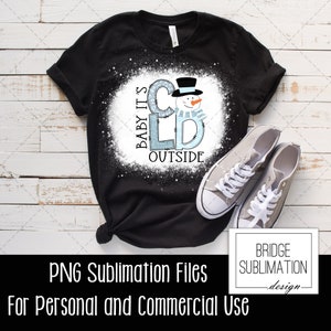 May include: A black t-shirt with a white splatter design featuring a snowman and the text "Baby It's Cold Outside".