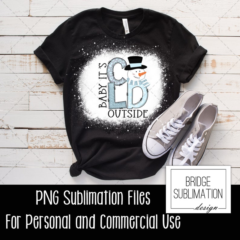 May include: A black t-shirt with a white splatter design featuring a snowman and the text "Baby It's Cold Outside".