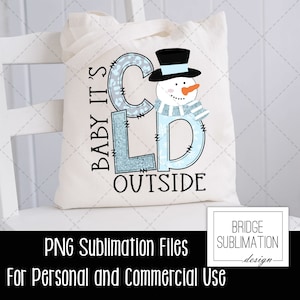 May include: A white tote bag with a blue and white snowman design. The text "Baby it's cold outside" is written in blue and white letters. The bag is for sublimation printing and is for personal and commercial use.
