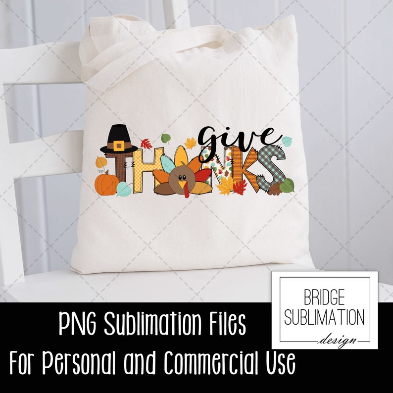 May include: A cream-colored tote bag with the words "give thanks" in a colorful, fall-themed design. The design includes a pilgrim hat, pumpkin, turkey, and autumn leaves. The bag is sitting on a white chair.