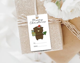 May include: White gift tag with a cartoon brown bear wearing a red Santa hat and holding a wrapped gift and a small Christmas tree. The tag says "Merry Christmas" and has blank lines for "To" and "From".