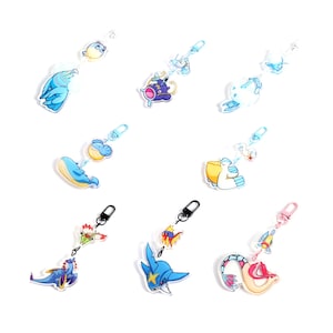 May include: A set of ten colorful keychains featuring various cartoon characters. The keychains are made of clear acrylic and feature a variety of colors, including blue, pink, yellow, and green. The characters include a blue whale, a pink seahorse, a yellow bird, and a green frog.