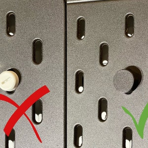 May include: Close-up of a gray pegboard with oval-shaped holes. A white peg is incorrectly inserted into a hole, marked with a red X. A gray peg is correctly inserted into a hole, marked with a green check.