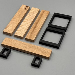 Peut inclure: Quatre bandes de bois et quatre cadres carr&eacute;s noirs dispos&eacute;s pour former un chariot de courses. Les bandes de bois sont brun clair et ont un grain de bois naturel. Les cadres noirs sont faits d'un mat&eacute;riau lisse et brillant.