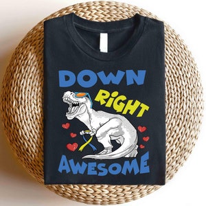 May include: Black t-shirt with a white dinosaur wearing sunglasses and a blue ribbon. The text "Down Right Awesome" is printed in blue and yellow letters.