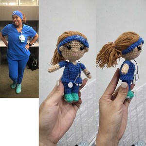 May include: A crocheted doll wearing a blue scrub top and a blue headband. The doll is holding a stethoscope and has brown hair.