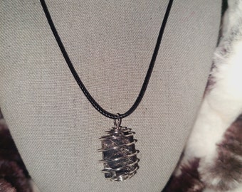 May include: A black cord necklace with a silver wire cage pendant containing a dark grey stone.