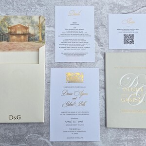 K&ouml;nnte beinhalten: Eine Sammlung von Hochzeitspapeterie, darunter eine Einladung mit einer Hausillustration, eine Detailkarte, eine RSVP-Karte mit QR-Code und ein Booklet mit den Initialen des Paares in Goldfolie.