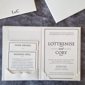 Luxuriöses Hardcover-Hochzeitseinladungset mit schwarzem Folienmuster auf elfenbeinfarbenem Papier mit RSVP und Detailskarte in einer Tasche