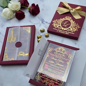 Invito di nozze personalizzato in scatola bordeaux con petali rossi, acrilico in foglia d'oro e carta velina personalizzata con nastro.