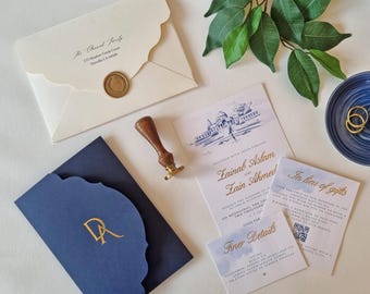 May include: Elegant wedding invitation suite featuring a navy blue invitation with gold lettering and a scalloped edge. Includes matching envelopes, RSVP cards, and a wax seal. A wooden handled stamp and gold rings are also present.