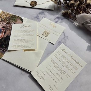 May include: A wedding invitation suite with a gold and white color scheme. The invitation features a special acknowledgment to the parents and godparents of the couple. The invitation includes the names of the bride and groom, "Doru & Cristina Varvaroi" and "Jason & Shelley Collins".