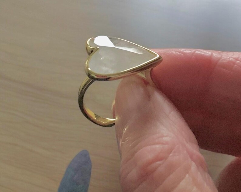 Puede incluir: Un anillo de oro con una piedra blanca en forma de coraz&oacute;n.