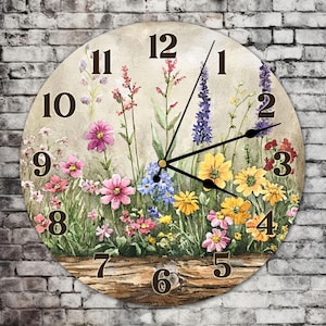 May include: A round clock with a floral design. The clock face has Roman numerals and a floral pattern with pink, yellow, blue, and purple flowers. The clock is surrounded by a wooden frame.