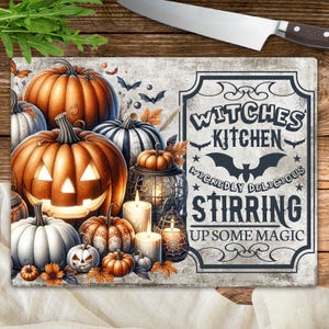 May include: A rectangular chopping board with a Halloween theme. It features orange pumpkins, lit candles, and the text "Witches Kitchen Wickedly Delicious Stirring Up Some Magic".
