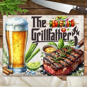 Puede incluir: Tabla de cortar rectangular con el texto "The Grillfather" e ilustraciones de cerveza, bistec, verduras y un cuchillo. La tabla tiene un fondo beige claro con textura de madera.