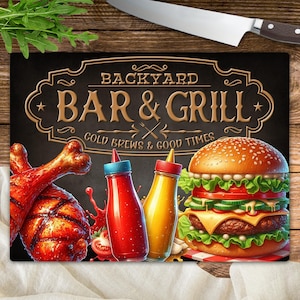 Könnte beinhalten: Rechteckiges Schneidebrett mit schwarzem Hintergrund. Es zeigt die Worte "BACKYARD BAR & GRILL" in goldfarbenen Buchstaben. Das Bild zeigt einen Burger, gebratenes Hähnchen und Ketchup- und Senfflaschen.