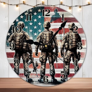 May include: A round wooden clock with an American flag design. Three soldiers in camouflage uniforms stand in front of the flag. The clock face has Roman numerals and black hands.
