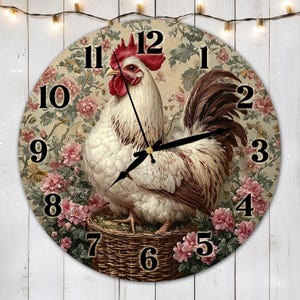 May include: A round clock with a white rooster with a red comb and wattle, surrounded by pink flowers and green leaves. The clock face has black Roman numerals and black hands.