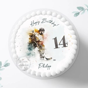Könnte beinhalten: Ein weißer Kuchen mit einem runden essbaren Bild eines Hockeyspielers im Aquarell-Stil. Das Bild enthält den Text "Happy Birthday!" und die Zahl "14". Der Kuchen ist mit weißem Frosting verziert und der Text "Laser stichchen Philipp" ist auf der Unterseite des Kuchens gedruckt.