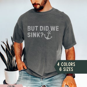 May include: A grey t-shirt with the text "But Did We Sink?" and an anchor graphic. The text is in a distressed font. The shirt is available in 4 colours and 6 sizes.