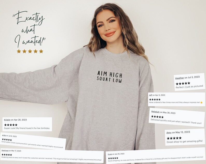 May include: A grey sweatshirt with the text "AIM HIGH SQUAT LOW" printed on the front. The sweatshirt is being modelled by a person. The image includes customer reviews with five stars and positive comments.